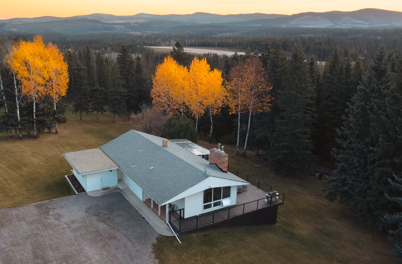 Aerial view of Willow House surrounded by forest and autumn aspens