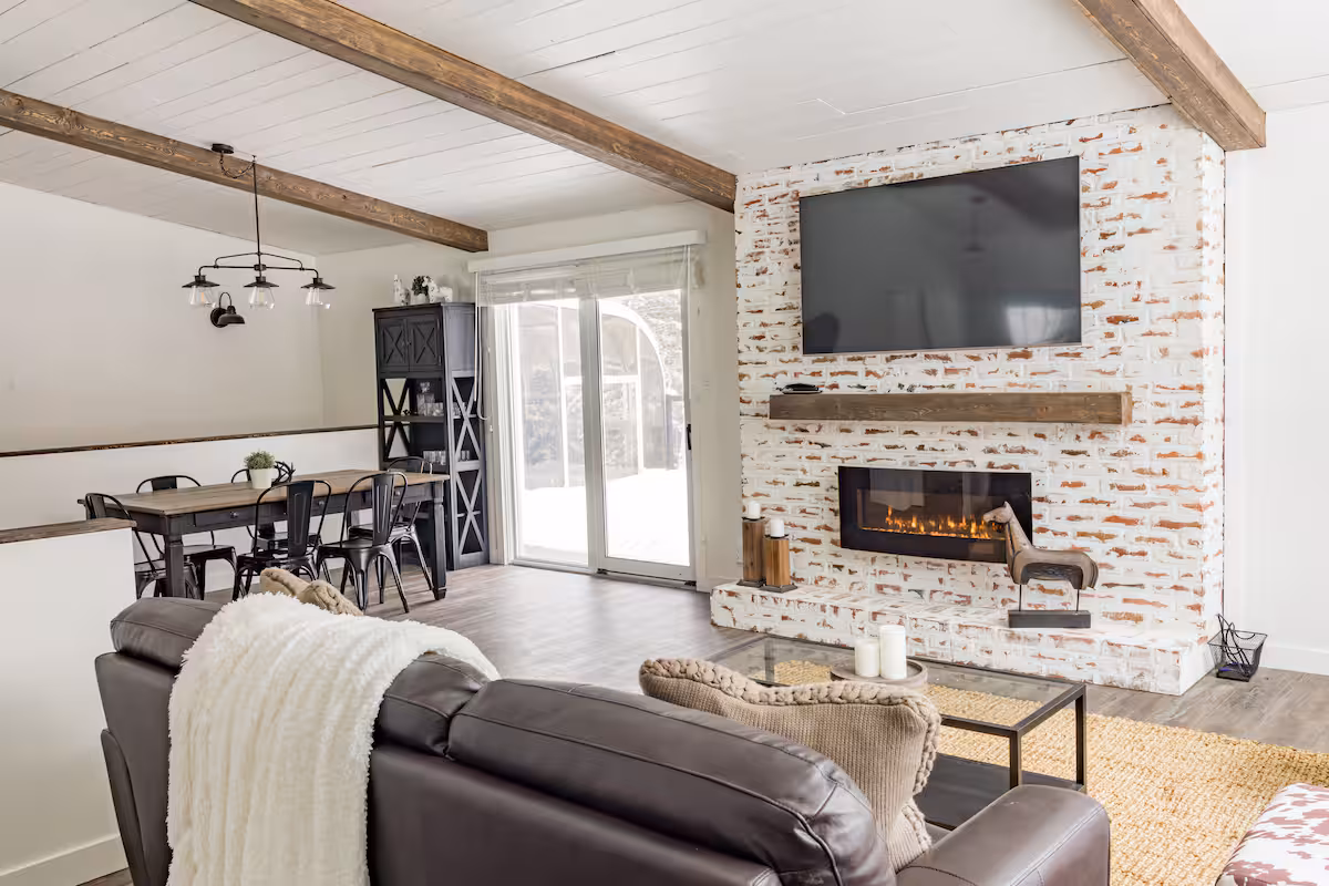 Open living and dining room with white brick fireplace